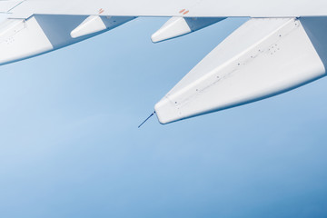 flying wing of a commercial airplane that is flying on the sky 
