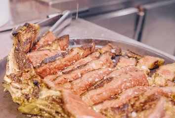 Grilled T-bone steak on a restaurant kitchen plate