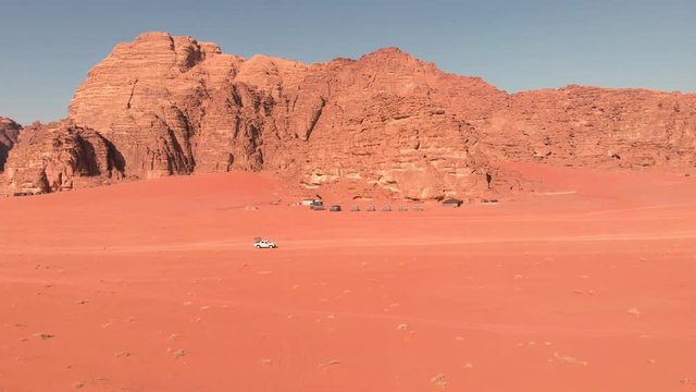 Safari off road jeep driving fast through the dry, red Wadi Rum desert in Jordan