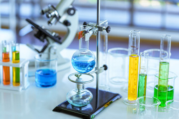Chemical glassware with blue liquids and test tubes on table in Laboratory