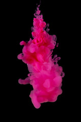 Abstract flowing pink color ink in water on black background.