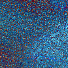 Pattern of randomly interwoven rings and balls of different diameters and blue and brown colors located on a motley background. Abstract fantasy.