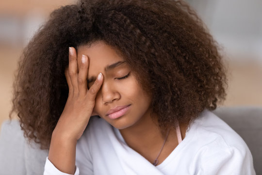 Sad or bored african american teen girl feeling headache sleepiness