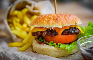 burger and french fries on wooden table. fast food