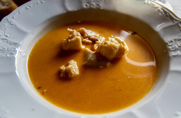 Spezialität aus Island: Feine skandinavische Fischsuppe mit cremiger roter Konsistenz von Tomaten mit Fisch und Sahne auf einem weißen Teller