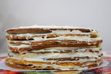 Cooking a festive multi-layer birthday cake. Scones and whipped cream. Laying a layer of banana cake for juicy pie.