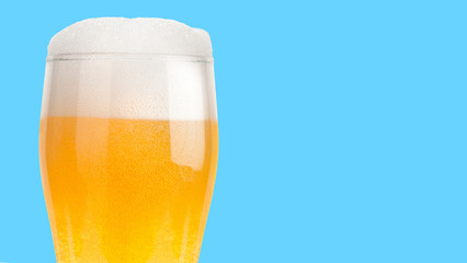 Glass of light beer isolated on blue