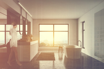 Woman walking in white bathroom and bedroom