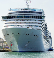 Huge modern cruiseship or cruise ship liner in port of Venice in Italy with cruise terminal and pier