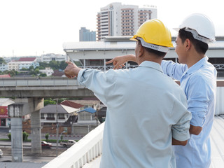 asian male engineer or foreman and architects Asian people are pointing to highrise building.