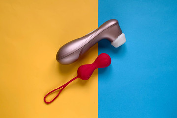 Sex toys. Geisha ball and vibrator on a blue-yellow background. Useful for sex shop, adult