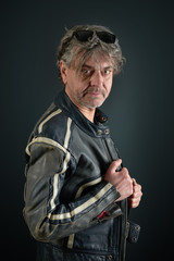 Portrait of a man with leather biker jacket on gradient background