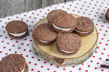 embossed cocoa cookies with vanilla cream on wooden logs