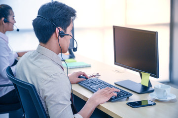 Young customer service men agent with headsets and computer working at office.