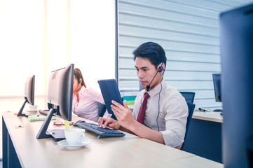 Young customer service men agent with headsets and computer working at office.