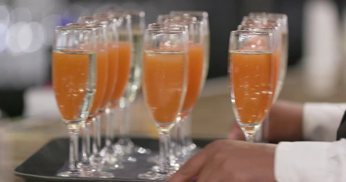 Waiter Delivering Glasses of Champagne, Martinis and Mimosas on Tray