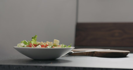 adding spices to make salad in white bowl