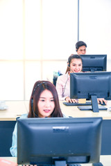 Young customer service women agent with headsets and computer working at office.