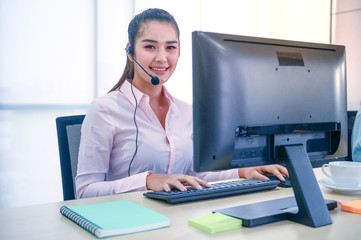 Young customer service women agent with headsets and computer working at office.