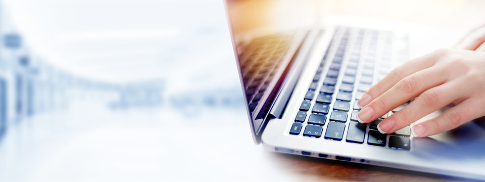 Business woman working on modern computer banner or panorama. Person buying online at internet. Laptop keyboard detail with hands copy space for text.