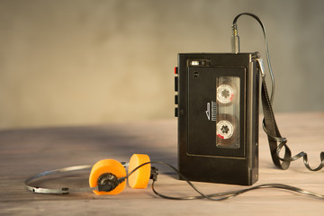 Old portable cassette player and headphones on a abstract background. Vintage advertisement style