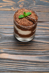 Classic tiramisu dessert in a glass cup on wooden background