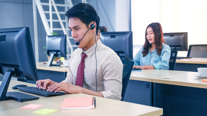 Young customer service men agent with headsets and computer working at office.
