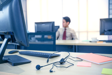 Close up headsets and computer monitor at office.