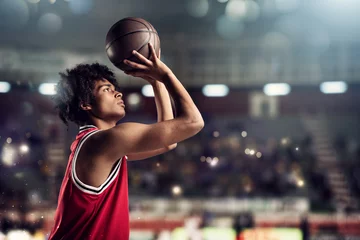 Schilderijen op glas Basketball player throws the ball in the basket in the stadium full of spectators © alphaspirit