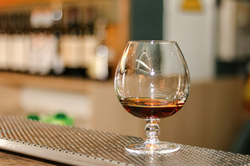 hand holding a glass of whiskey at the bar