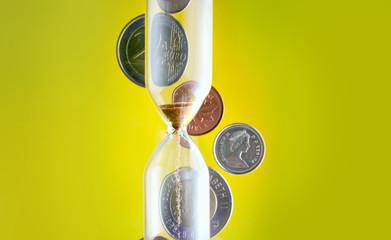 hourglass with coins in the background