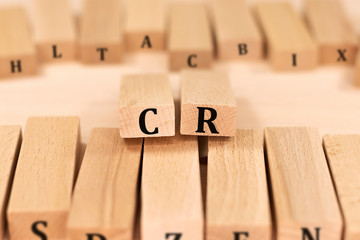 CR word background on wood blocks. business concept