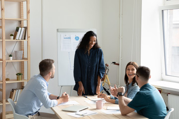 Fototapeta premium Happy young african american female speaker chatting with workshop participants.