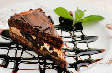 chocolate cake with a brown topping and sprig of mint