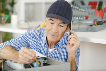 a senior electrician repairing machine © auremar