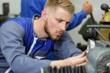 young engineer using machinery in workshop