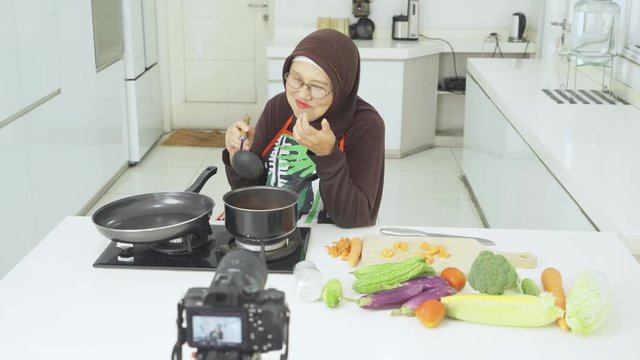 Elderly chef cooking and recording a video blog