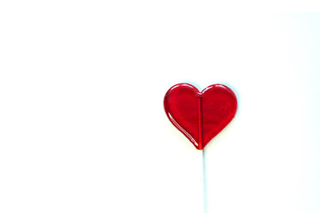 Fototapeta na wymiar red heart shaped lollipop isolated on a white background