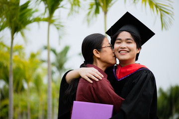 Graduation ceremony. Young female graduate hugging each other with her mother congratulate the...