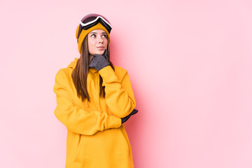 Young caucasian skier woman isolated looking sideways with doubtful and skeptical expression.