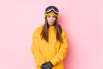 Young caucasian skier woman isolated shrugs shoulders and open eyes confused.