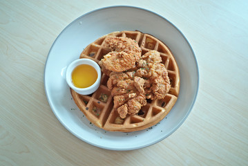 Hot deep-fried crunchy super crispy southern-style chicken with  fluffy classic Belgian waffles recipe served with sweet honey sauce is delicious fusion cuisine as famous food menu in restaurant