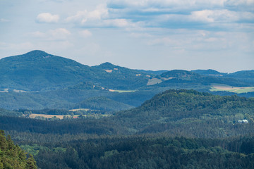 Pravcicka brana in Bohemian Switzerland. Prebischtor Gate mountain view. Narrow rock, largest natural sandstone arch in Europe. Hill scenery with greenery, blue sky and sunlight, natural environment.