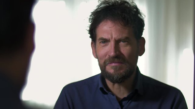 Sad man starting to cry in front of mirror