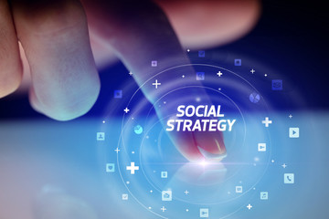 Finger touching tablet with social media icons and SOCIAL STRATEGY