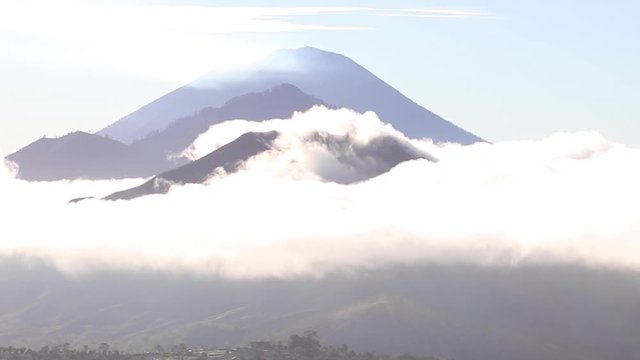 View of three bali volcanoes in the clouds at dawn. Agung, Batur and Abang