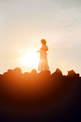 silhouette of woman praying over beautiful sky background