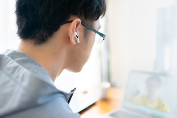 部屋着でリモートワークする会社員男性