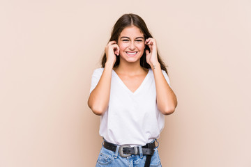 Young caucasian woman posing isolated covering ears with hands.