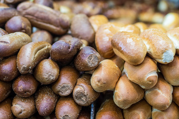 Fresh baguettes, half whole flour and half white. Arranged in a stack on top of each other, against a blurred background. The Market, Jerusalem.